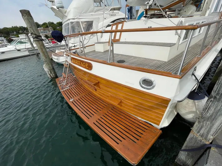 Meritage Yacht Photos Pics 1990 Grand Banks 42 Classic yacht docked, featuring wooden deck and swim platform.