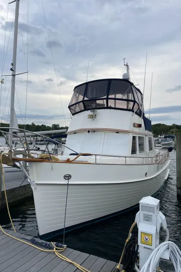 Meritage Yacht Photos Pics Grand Banks 42 Classic 1990 yacht docked at marina under cloudy sky.