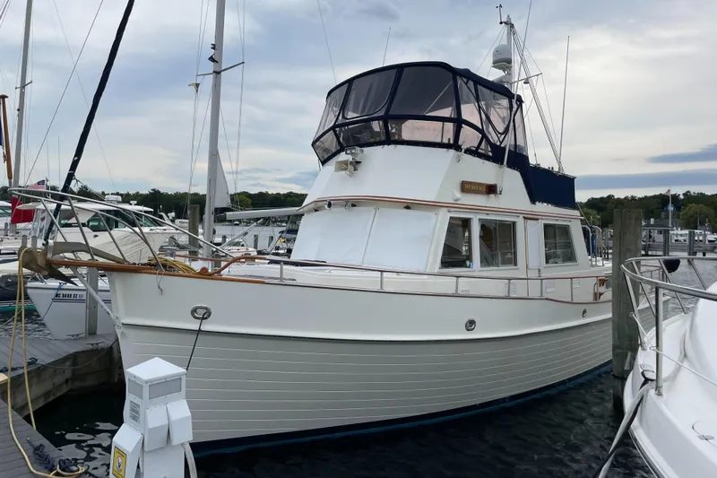 Meritage Yacht Photos Pics 1990 Grand Banks 42 Classic yacht docked at a marina under cloudy skies.