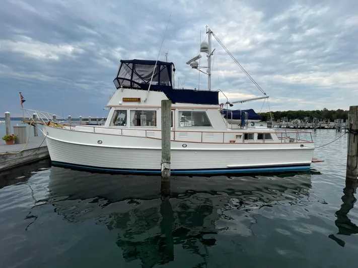 Meritage Yacht Photos Pics 1990 Grand Banks 42 Classic yacht docked at a marina under cloudy skies.