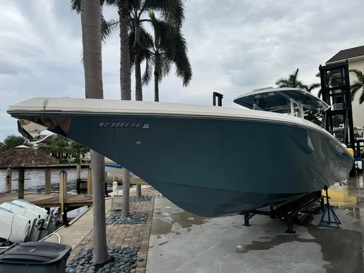 Re-powered-2022 Yacht Photos Pics 2019 Fountain 38 CC boat docked near palm trees, overcast sky.