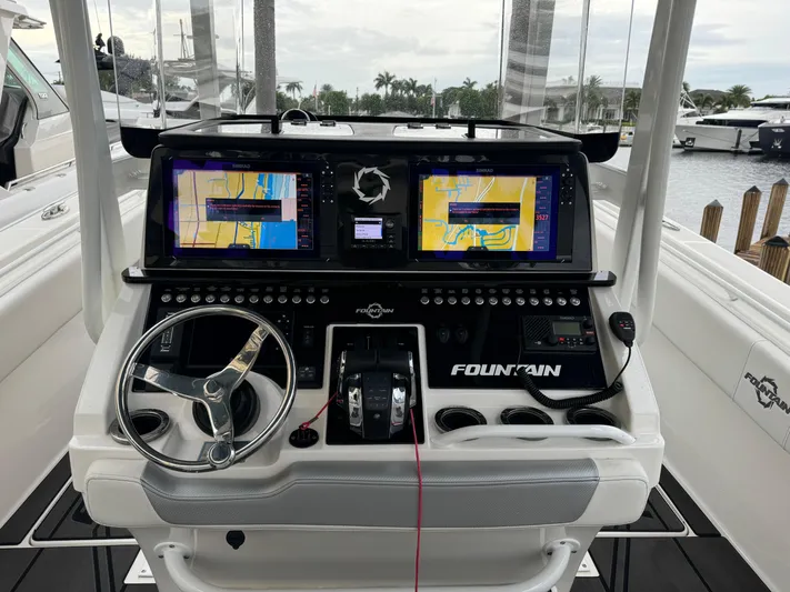 Re-powered-2022 Yacht Photos Pics 2019 Fountain 38 CC boat dashboard with dual navigation screens and steering wheel.