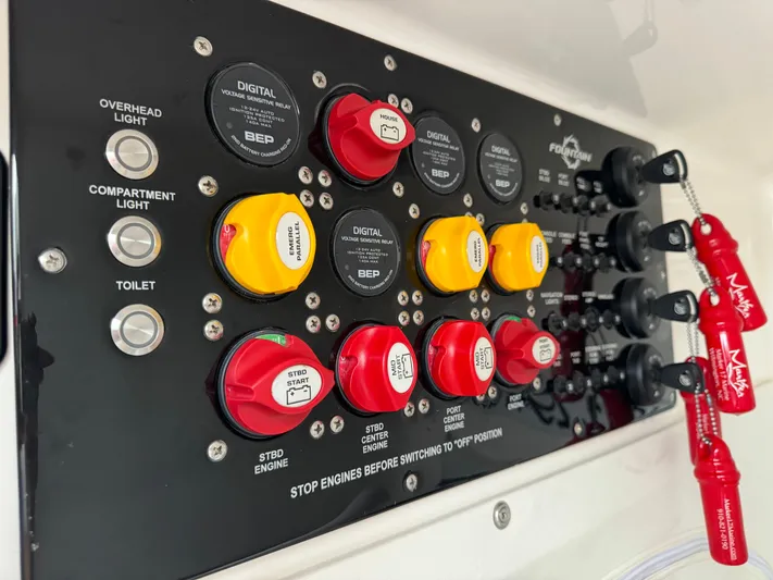 Re-powered-2022 Yacht Photos Pics Control panel of a 2019 Fountain 38 CC boat with labeled switches and keys.
