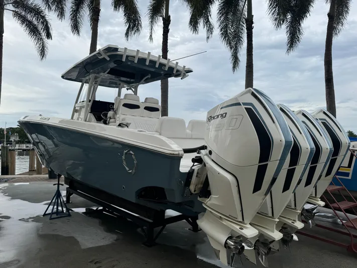 Re-powered-2022 Yacht Photos Pics 2019 Fountain 38 CC boat with multiple outboard engines, docked under palm trees.