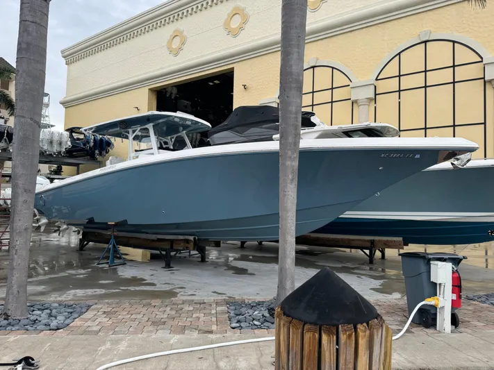 Re-powered-2022 Yacht Photos Pics 2019 Fountain 38 CC boat in dry dock, blue hull, marina setting.