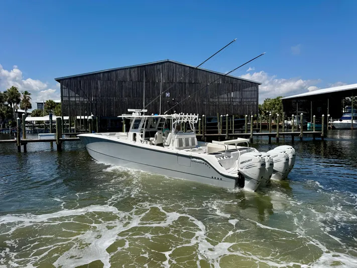  Yacht Photos Pics 2022 Invincible 46 Catamaran in marina, featuring twin outboard engines, under clear blue sky.