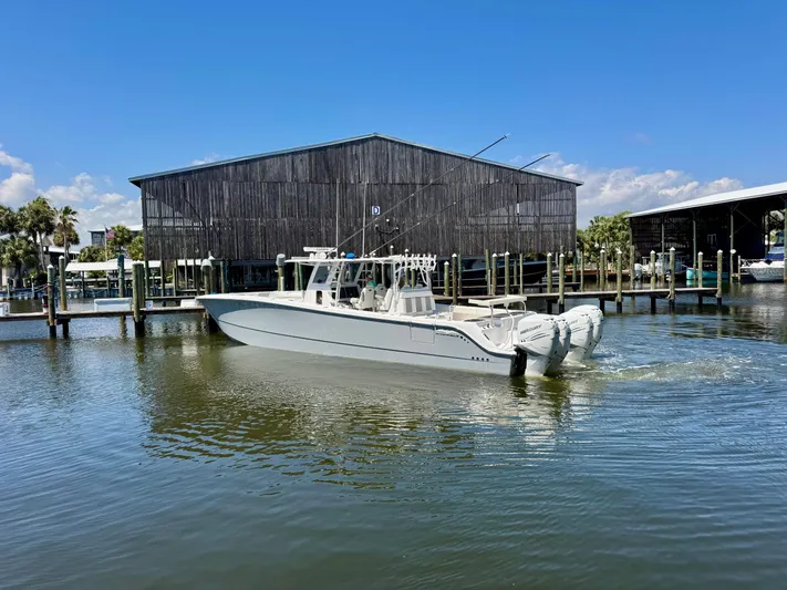  Yacht Photos Pics 2022 Invincible 46 Catamaran cruising near a marina under a clear blue sky.