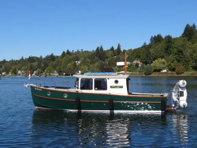 Devlin Surf Scoter 2000 boat on a calm lake with forested shoreline.
