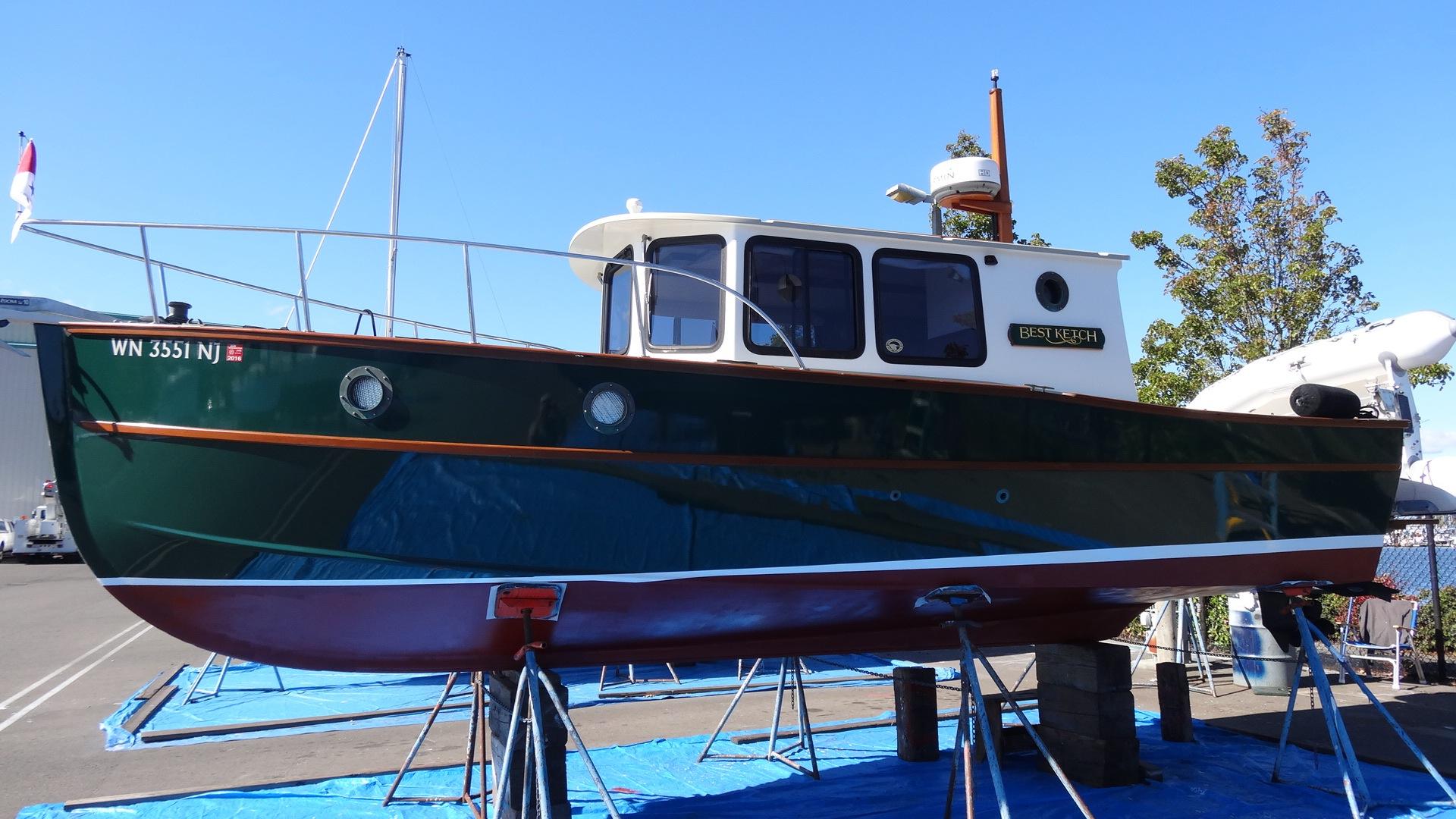 2000 Devlin Surf Scoter boat on stands, green hull, docked outdoors.