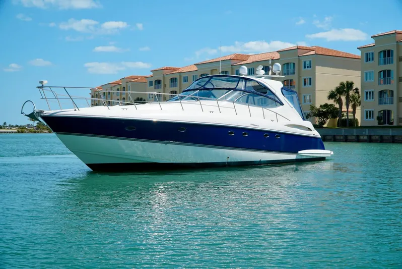 Kaizen Yacht Photos Pics 2007 Cruisers Yachts 560 Express in a marina with waterfront condos.