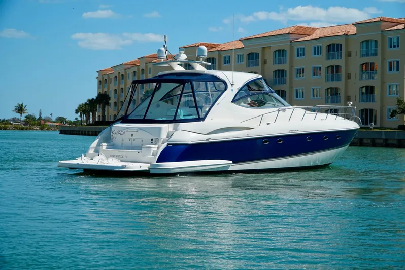 Kaizen Yacht Photos Pics 2007 Cruisers Yachts 560 Express in a marina with waterfront buildings.