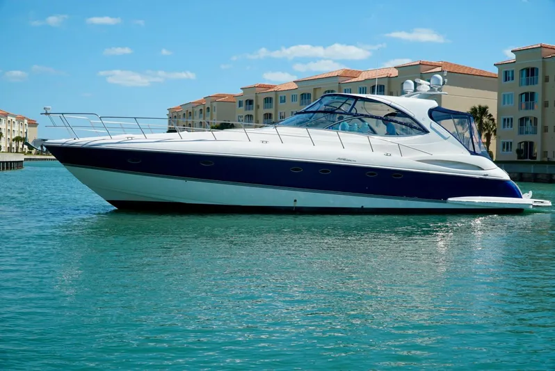 Kaizen Yacht Photos Pics 2007 Cruisers Yachts 560 Express luxury yacht on calm water near waterfront buildings.