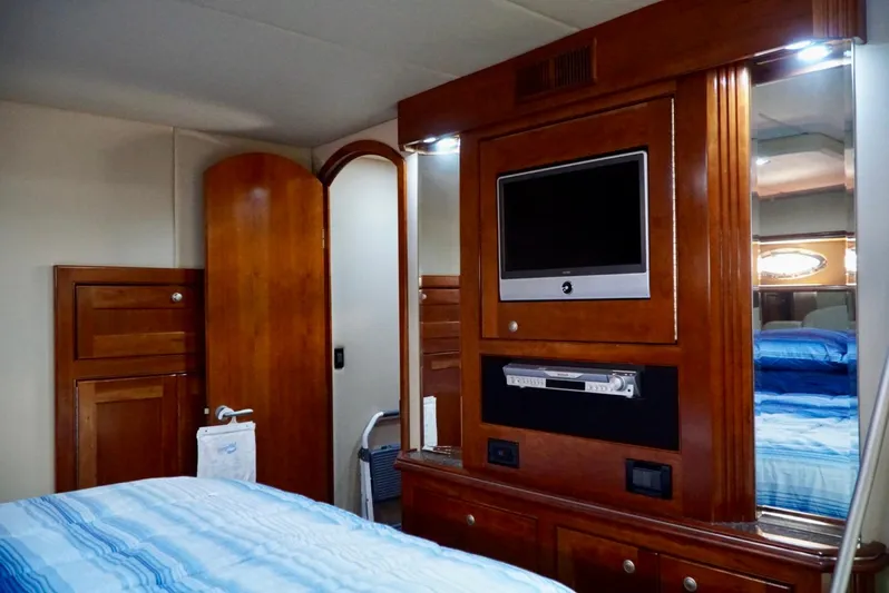 Kaizen Yacht Photos Pics Luxurious bedroom interior of 2007 Cruisers Yachts 560 Express with TV and wooden cabinetry.