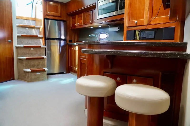 Kaizen Yacht Photos Pics Luxurious 2007 Cruisers Yachts 560 Express interior with modern kitchen and bar stools.