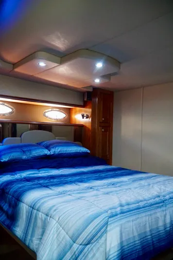 Kaizen Yacht Photos Pics Luxurious bedroom interior of 2007 Cruisers Yachts 560 Express with blue bedding.