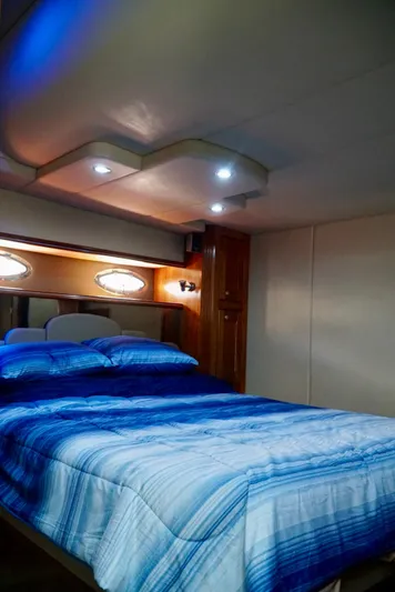 Kaizen Yacht Photos Pics Luxurious bedroom interior of 2007 Cruisers Yachts 560 Express with blue bedding.
