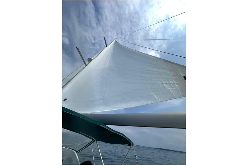Gemini's Escape II Yacht Photos Pics Sailing on a 2005 Beneteau Oceanis 42CC with white sails against a cloudy sky.