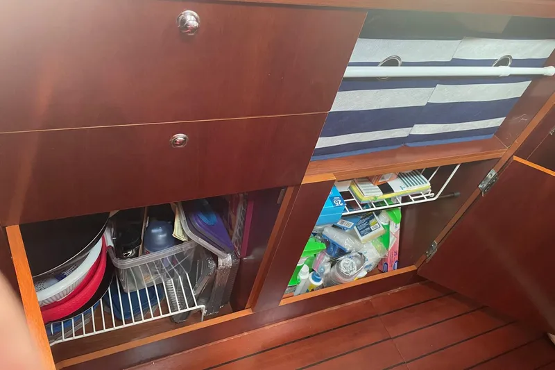 Gemini's Escape II Yacht Photos Pics Storage cabinets inside a 2005 Beneteau Oceanis 42CC yacht, featuring organized supplies.