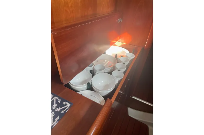 Gemini's Escape II Yacht Photos Pics Cabinet with dishes and cups inside a 2005 Beneteau Oceanis 42CC yacht.