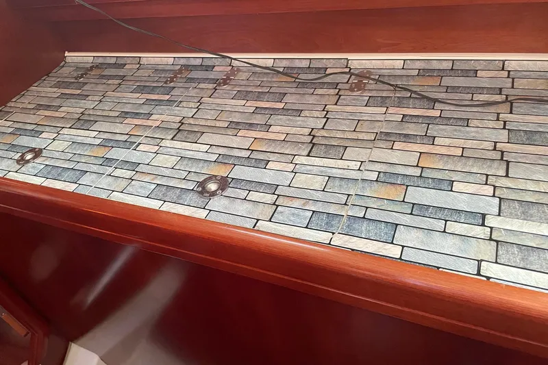 Gemini's Escape II Yacht Photos Pics Interior of 2005 Beneteau Oceanis 42CC with stone-patterned countertop and wooden trim.