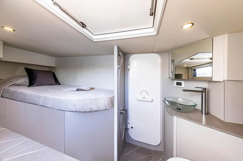  Yacht Photos Pics Luxurious interior of 2026 Absolute Navetta 53 yacht featuring a cozy bedroom and modern bathroom.
