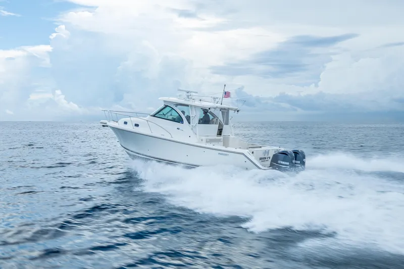 "seven C's" Yacht Photos Pics 2011 Pursuit OS 345 Offshore boat cruising on open ocean with cloudy sky.