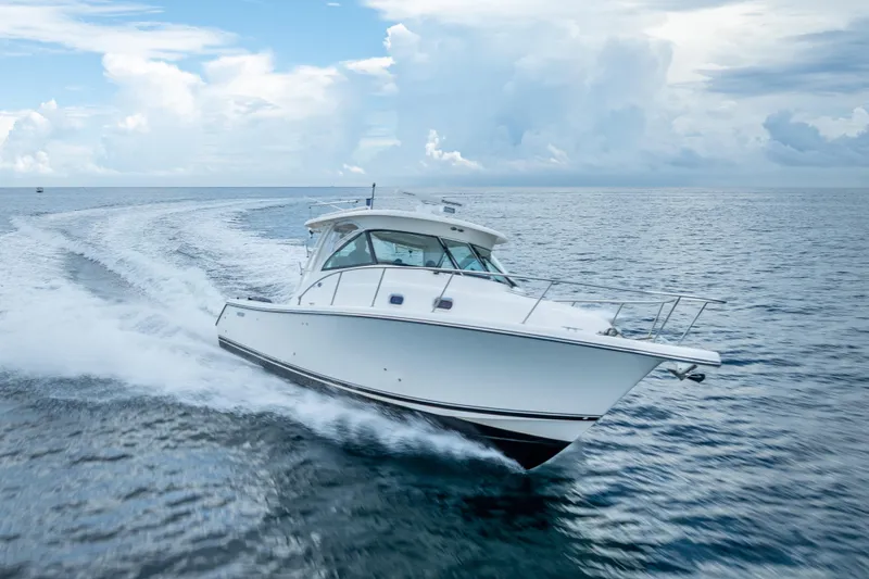 "seven C's" Yacht Photos Pics 2011 Pursuit OS 345 Offshore boat cruising on open ocean under cloudy sky.