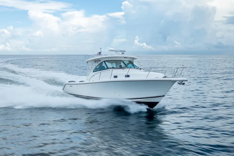 "seven C's" Yacht Photos Pics 2011 Pursuit OS 345 Offshore boat cruising on open water under a cloudy sky.