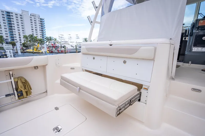 "seven C's" Yacht Photos Pics 2011 Pursuit OS 345 Offshore boat interior with fold-out seating and storage, docked near buildings.