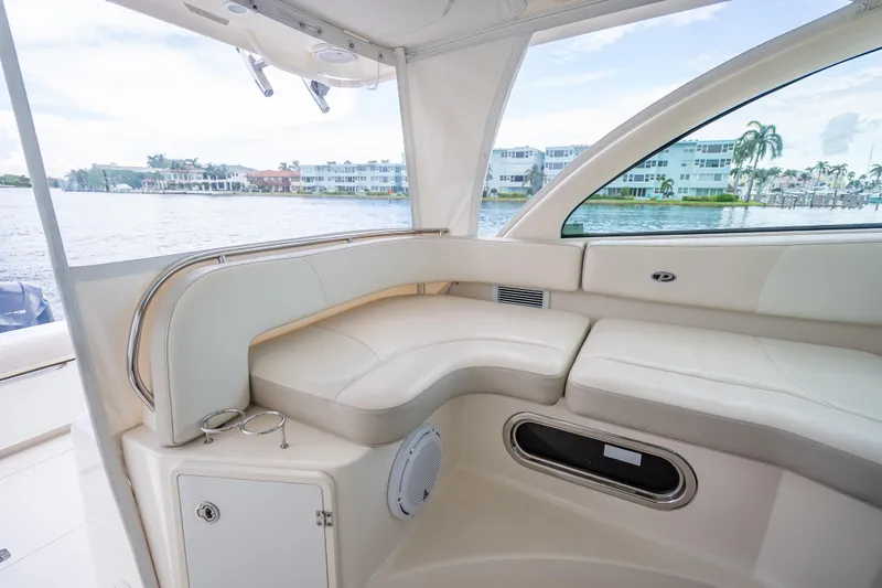 "seven C's" Yacht Photos Pics 2011 Pursuit OS 345 Offshore boat interior with cream seating, overlooking waterfront homes.