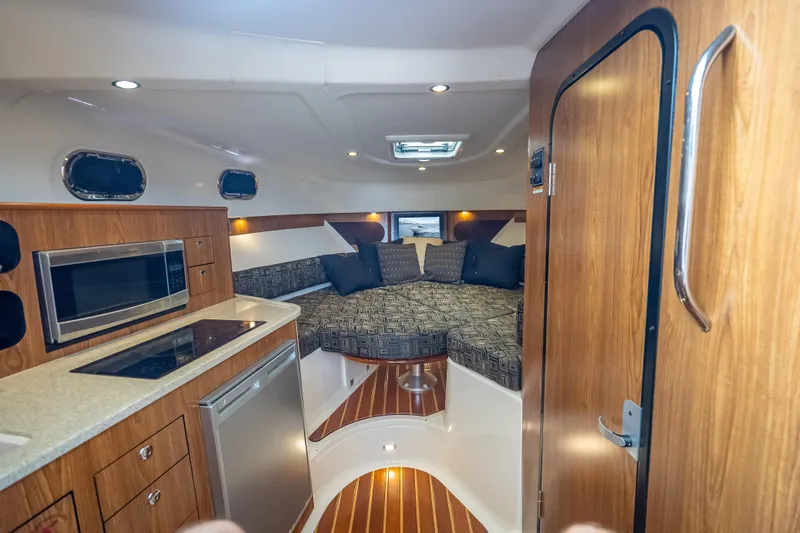"seven C's" Yacht Photos Pics Interior of 2011 Pursuit OS 345 Offshore boat with kitchenette and cozy seating area.