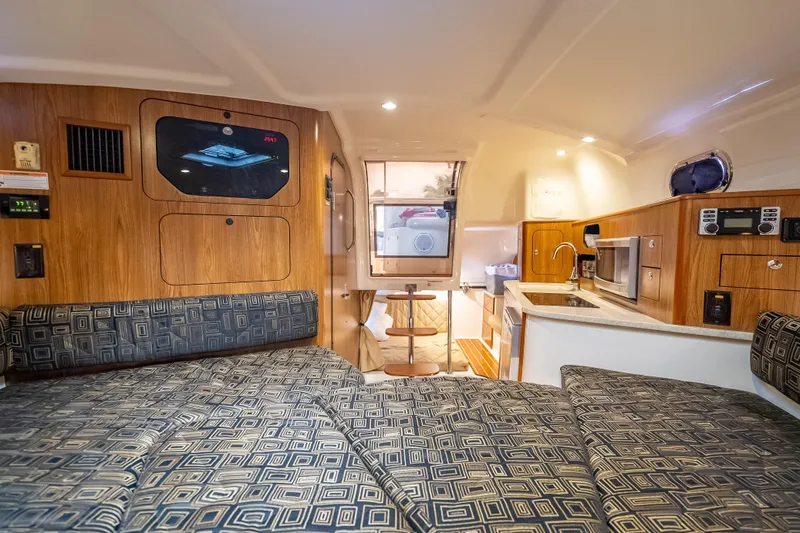 "seven C's" Yacht Photos Pics Interior of 2011 Pursuit OS 345 Offshore boat with cozy seating and kitchenette.