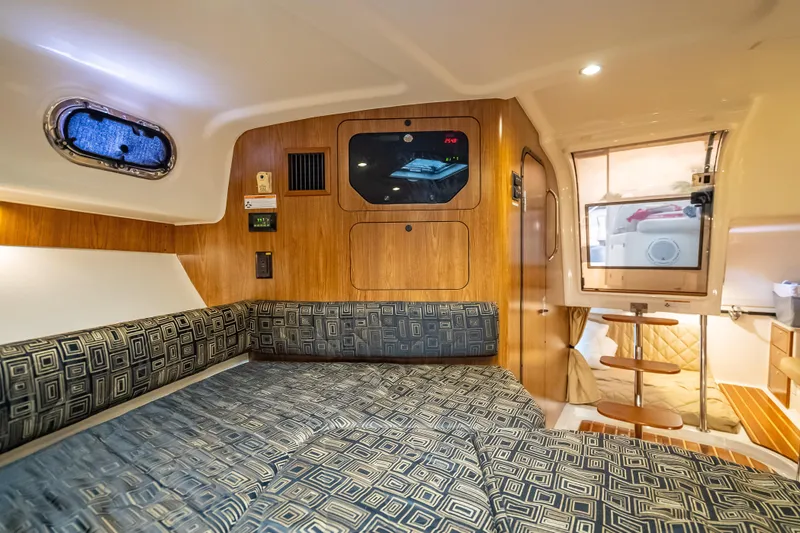 "seven C's" Yacht Photos Pics 2011 Pursuit OS 345 Offshore cabin interior with patterned seating and wooden accents.