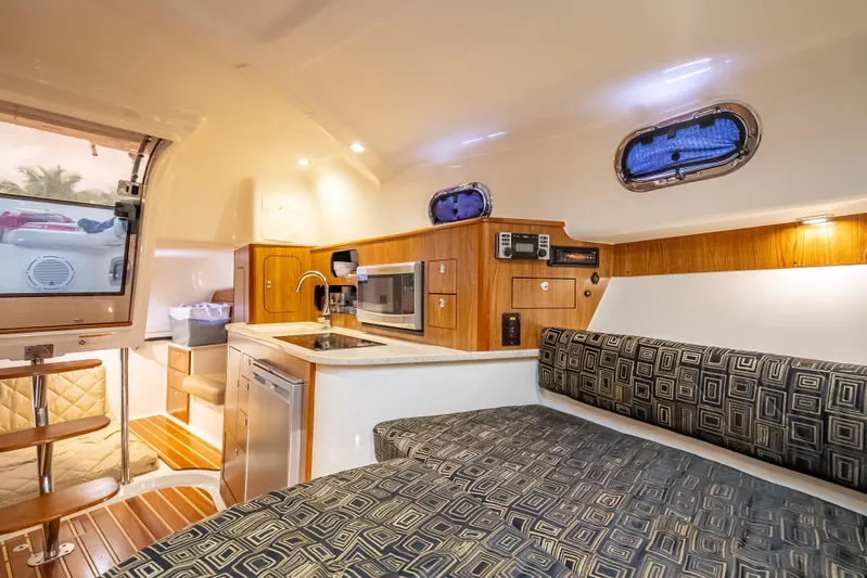 "seven C's" Yacht Photos Pics 2011 Pursuit OS 345 Offshore cabin interior with kitchenette, seating, and modern amenities.