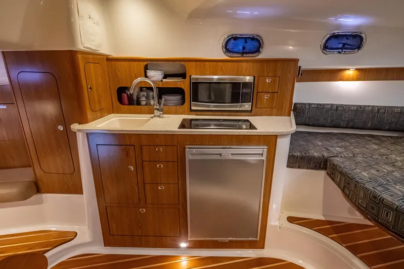 "seven C's" Yacht Photos Pics 2011 Pursuit OS 345 Offshore yacht interior with kitchenette and seating area.
