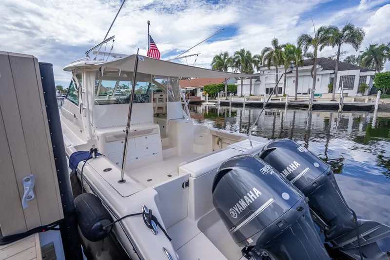 "seven C's" Yacht Photos Pics 2011 Pursuit OS 345 Offshore boat docked, featuring dual Yamaha engines, palm trees in background.
