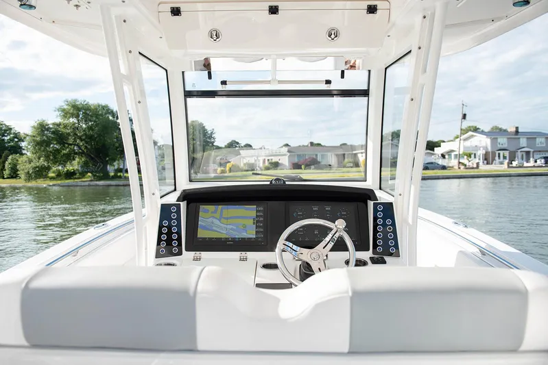  Yacht Photos Pics 2020 Robalo R302 CC boat helm with navigation display on calm water.