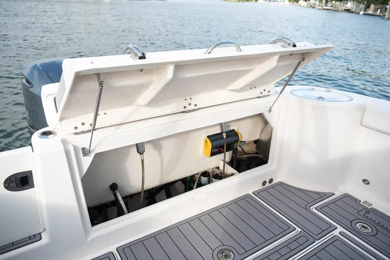  Yacht Photos Pics 2020 Robalo R302 CC boat storage compartment with open hatch.