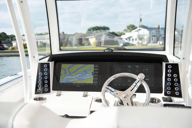  Yacht Photos Pics 2020 Robalo R302 CC boat dashboard with navigation screens and steering wheel.