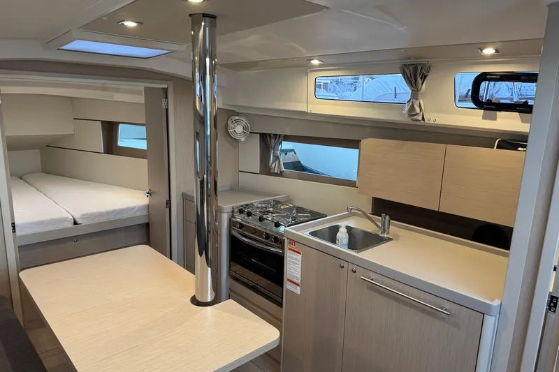Barcelona Yacht Photos Pics Modern interior of 2021 Beneteau Oceanis 35.1 yacht with kitchen and sleeping area.