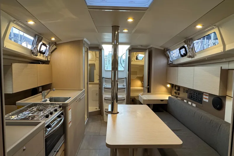 Barcelona Yacht Photos Pics Modern interior of 2021 Beneteau Oceanis 35.1 yacht with kitchen and seating area.