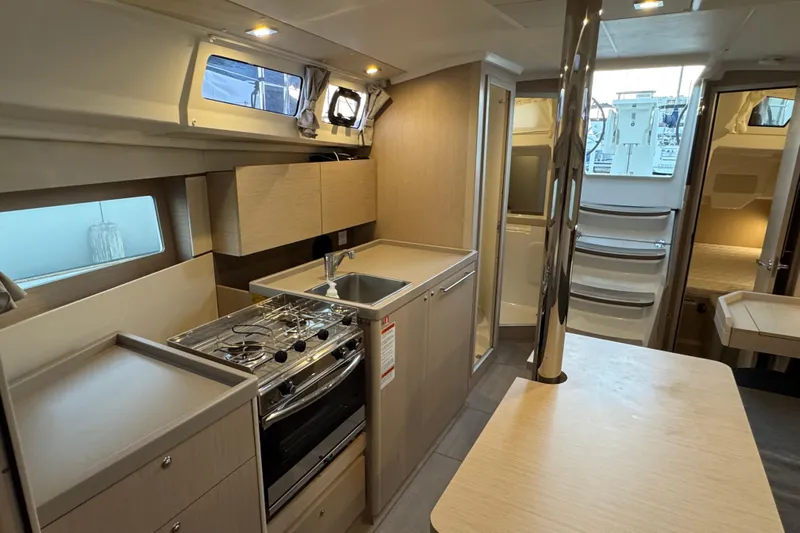 Barcelona Yacht Photos Pics Modern interior of 2021 Beneteau Oceanis 35.1 yacht with kitchen and dining area.