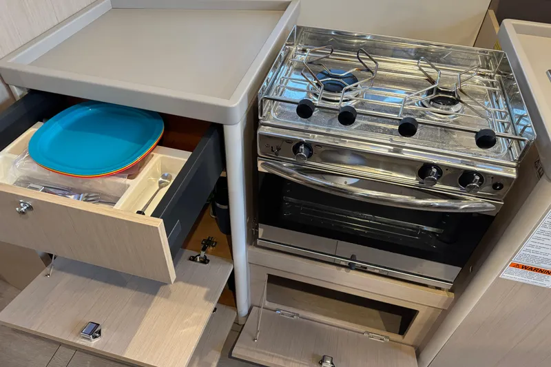 Barcelona Yacht Photos Pics Interior of 2021 Beneteau Oceanis 35.1 yacht kitchen with stove and storage drawers.