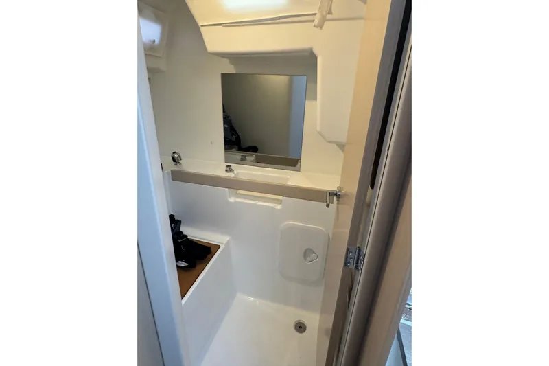 Barcelona Yacht Photos Pics Bathroom interior of 2021 Beneteau Oceanis 35.1 yacht, featuring a compact sink and mirror.