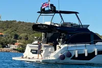 2023 Cranchi F 52 yacht on water, featuring a British flag and scenic background.