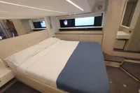 Luxurious bedroom interior of 2023 Cranchi F 52 yacht with modern design and cozy bedding.