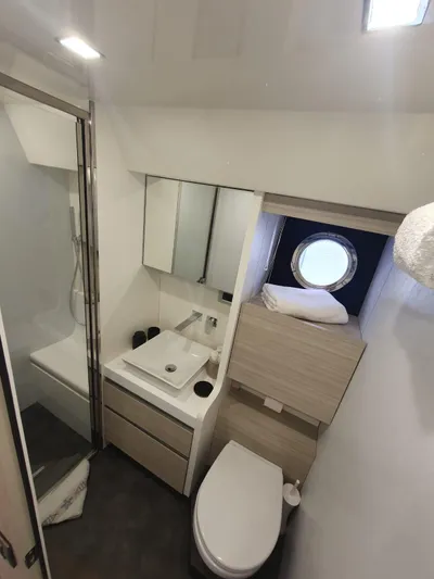 Avalon Yacht Photos Pics Modern bathroom in 2023 Cranchi F 52 yacht with shower, sink, and porthole window.