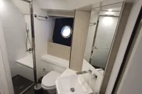 Modern bathroom in 2023 Cranchi F 52 yacht, featuring sleek fixtures and a porthole window.