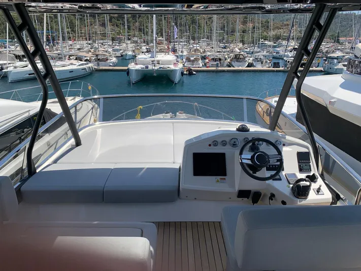 Avalon Yacht Photos Pics 2023 Cranchi F 52 yacht helm with marina view, featuring modern controls and seating.