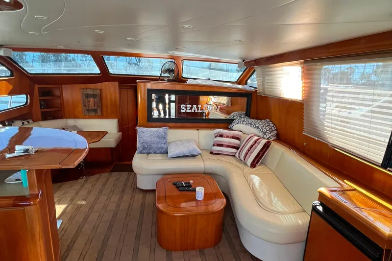 The Donut Hull Yacht Photos Pics Luxurious interior of 2002 Mikelson 50 Flybridge yacht with plush seating and wooden accents.